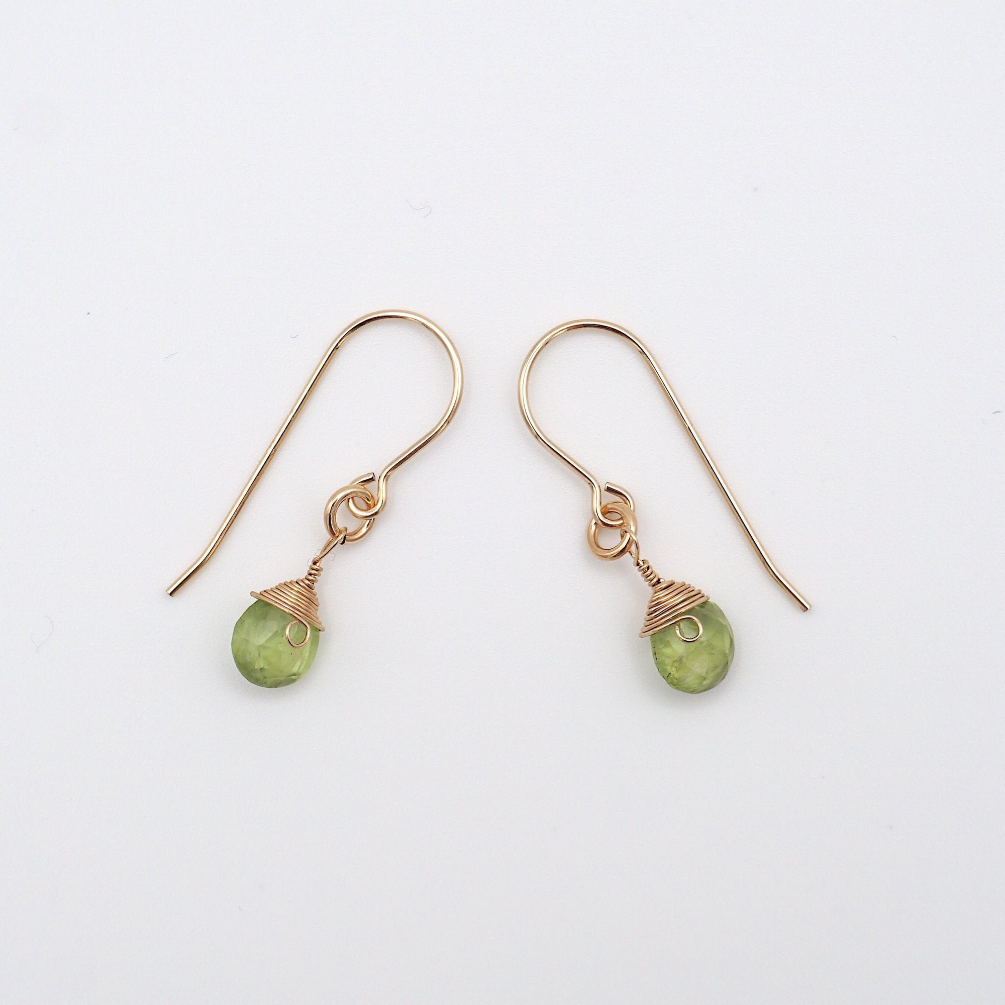 Side angle of peridot drop earrings, minimalist artisan wire wrapping, 14k gold filled
