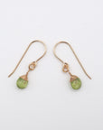 Side angle of peridot drop earrings, minimalist artisan wire wrapping, 14k gold filled