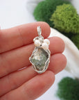 Peridot and freshwater pearl pendant necklace in hand for size reference, silver wire wrapped, handcrafted gemstone jewelry
