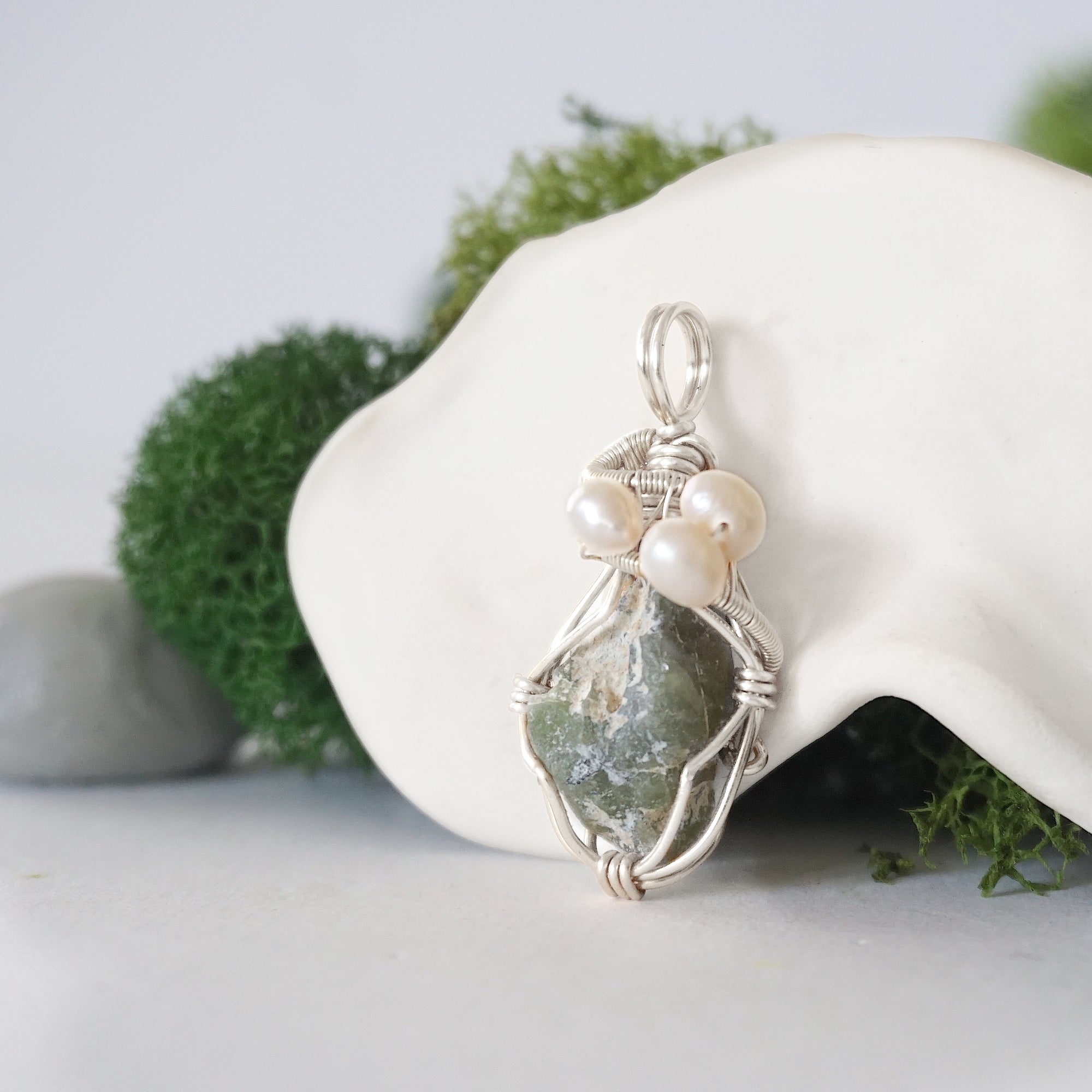 Side angle of handmade peridot and freshwater pearl pendant necklace, silver wire wrapped jewelry