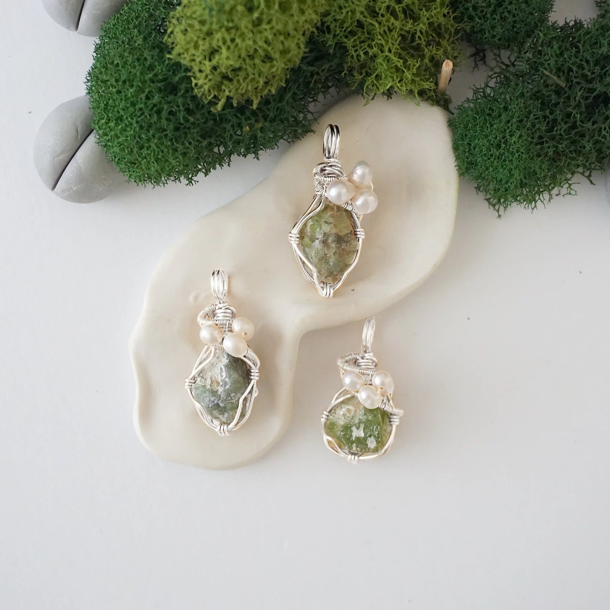 Three silver wire wrapped peridot and freshwater pearl pendants showing natural stone variation, artisan jewelry for women