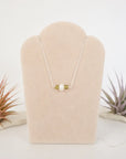 Peridot and freshwater pearl bar necklace in 925 sterling silver on jewelry display, front view