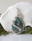 Back angle detail of polished raw emerald pendant necklace for women with natural emerald and handcrafted sterling silver wrapping