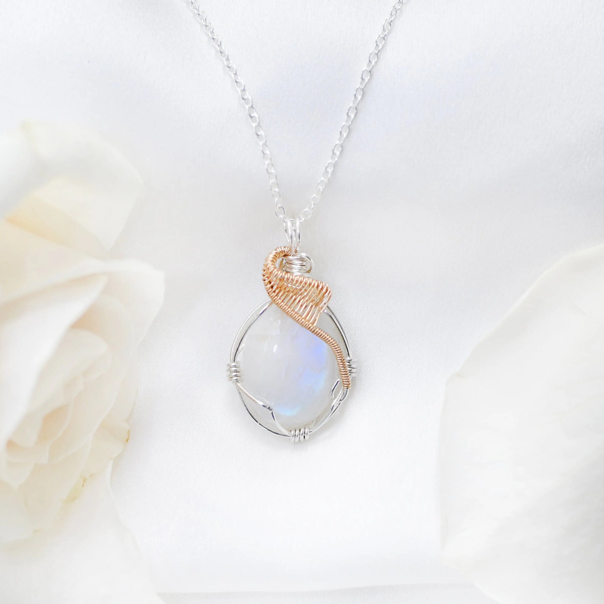 Close-up of natural rainbow moonstone cabochon necklace with sterling silver and 14k gold filled artisan wire wrapping (June birthstone).