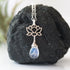 Close-up of rainbow moonstone and lotus necklace for women, faceted pear rainbow moonstone drop with 925 sterling silver lotus charm on sterling silver chain (June birthstone).