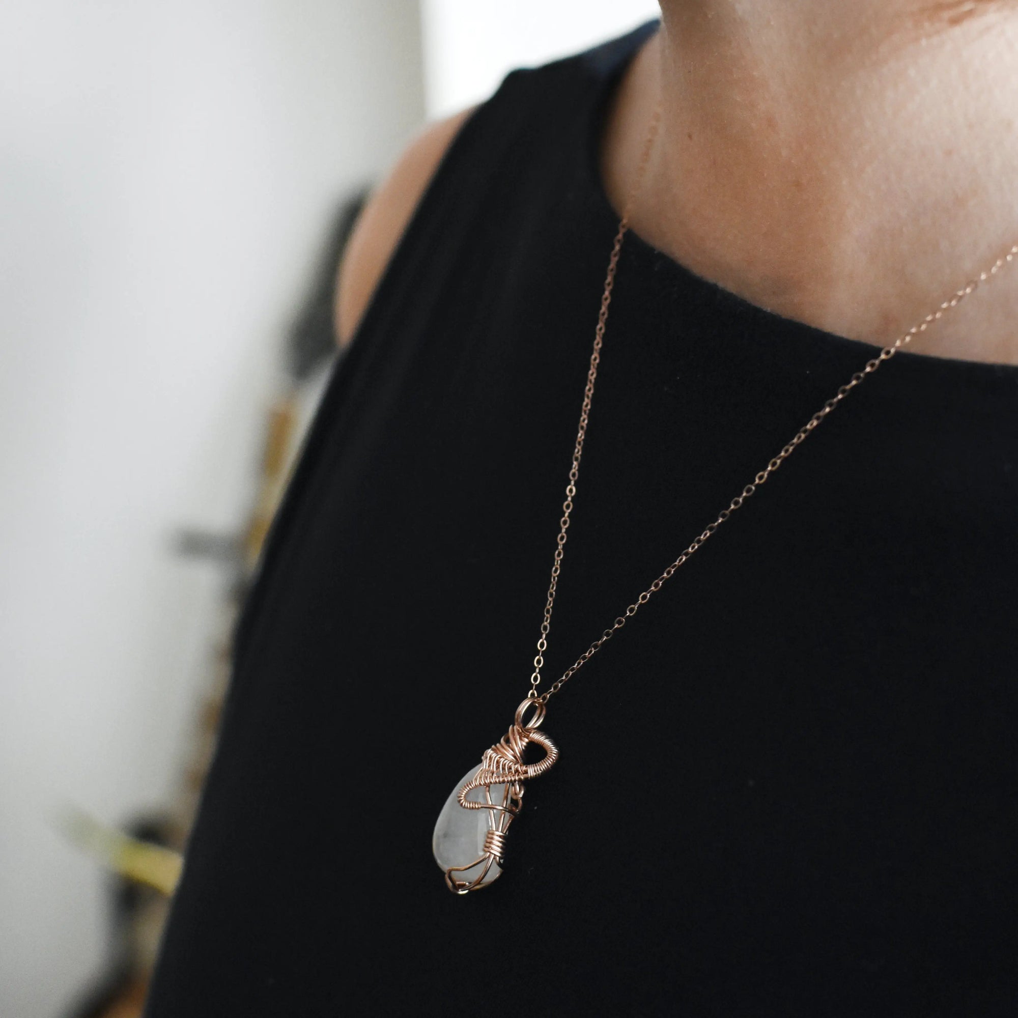 Model wearing rainbow moonstone necklace with 14k rose gold filled chain and handmade cabochon pendant