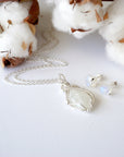 Rainbow moonstone pendant on sterling silver chain with raw rainbow moonstone stud earrings displayed together as a jewelry set.