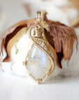 Front angle view of natural rainbow moonstone cabochon pendant with detailed 14k gold filled wire wrapping