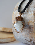 Left angle view of natural rainbow moonstone pendant highlighting artisan mixed metal wire wrapping