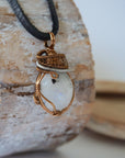 Right angle view of rainbow moonstone pendant showing handcrafted antique bronze and dark silver wire wrapping detail