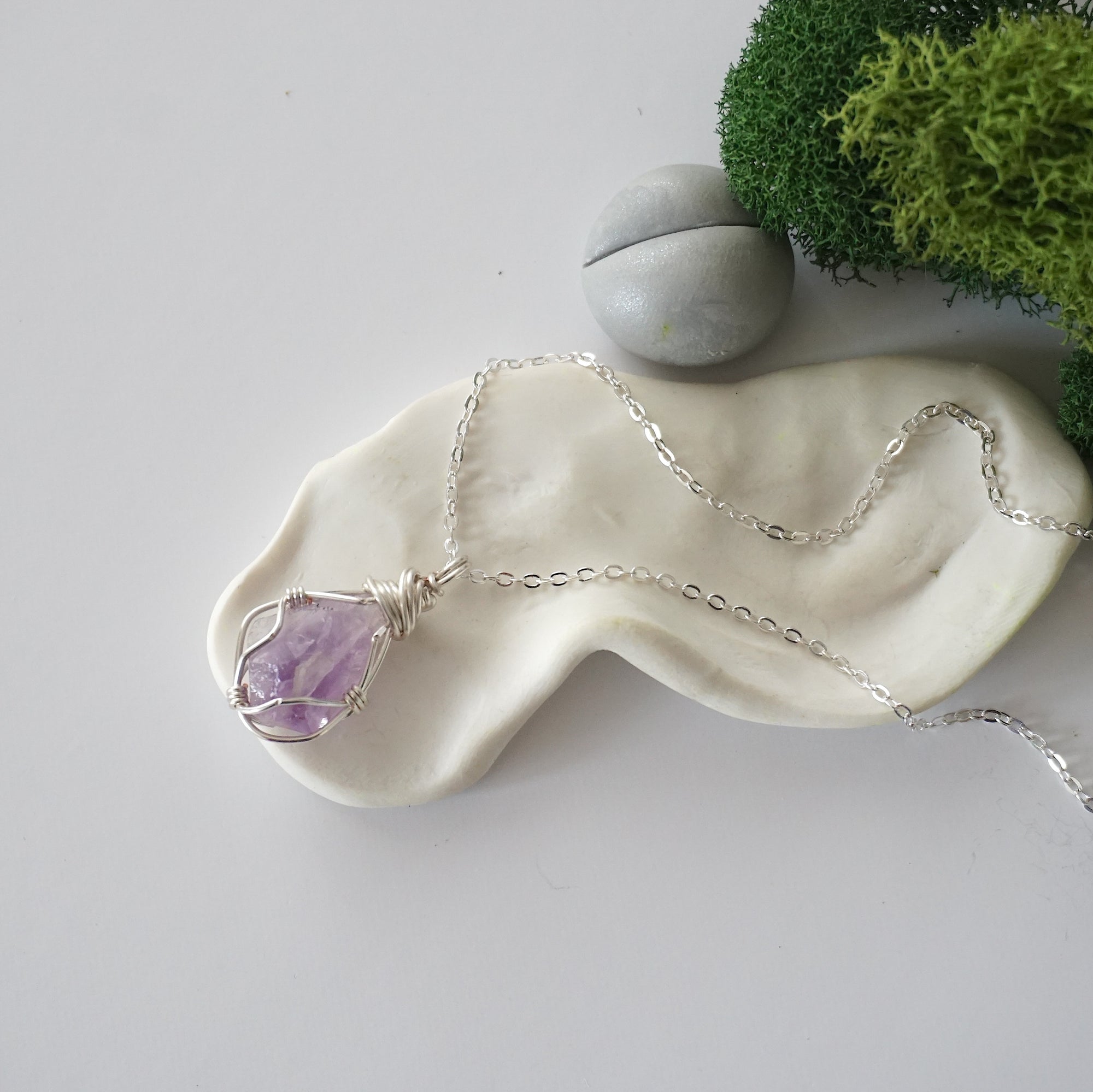Simple raw amethyst necklace with silver plated brass chain laying flat