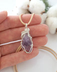 Handmade raw amethyst pendant held in hand showing size — natural lavender amethyst stone wire wrapped in 925 sterling silver, 10-15 carats, one of a kind