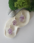 Three different raw amethyst pendants displayed for variation reference