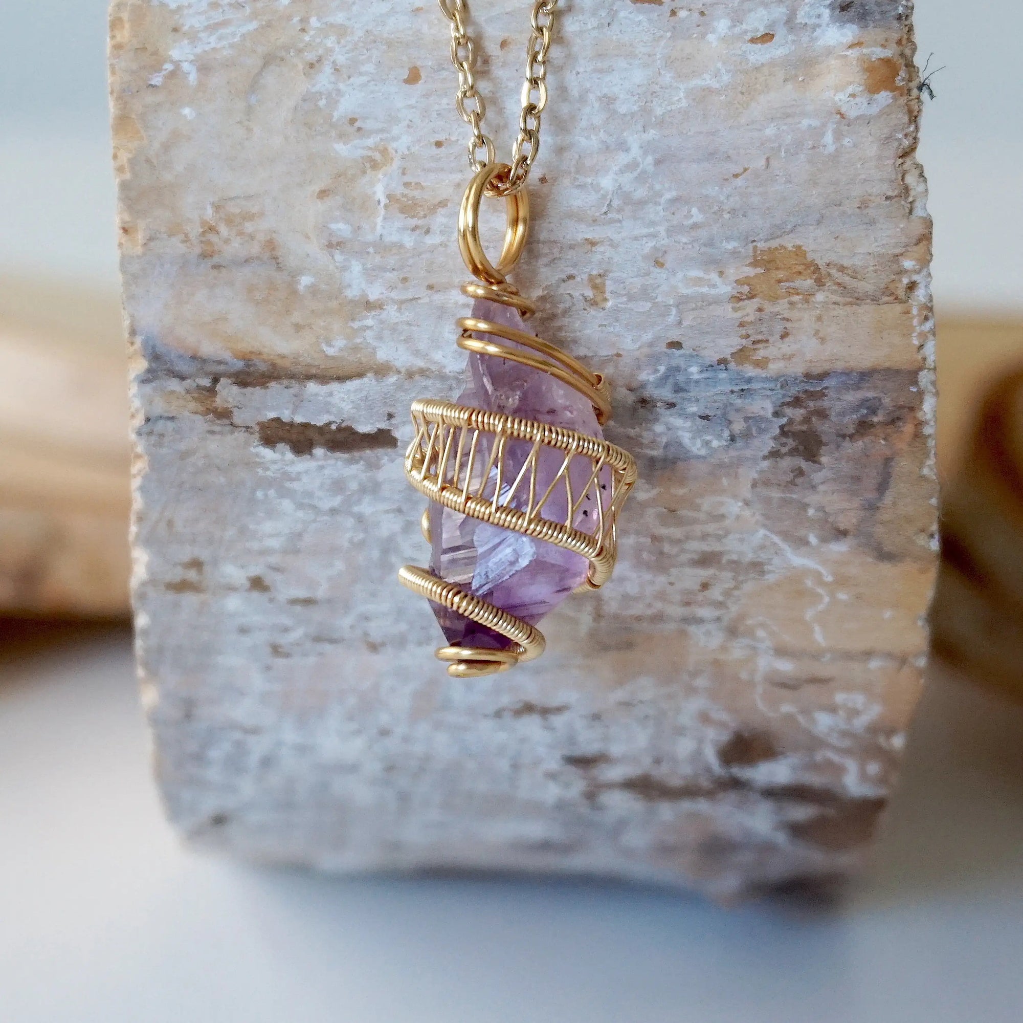 Front view of raw amethyst point necklace with detailed gold plated copper wire wrap on gold plated brass chain