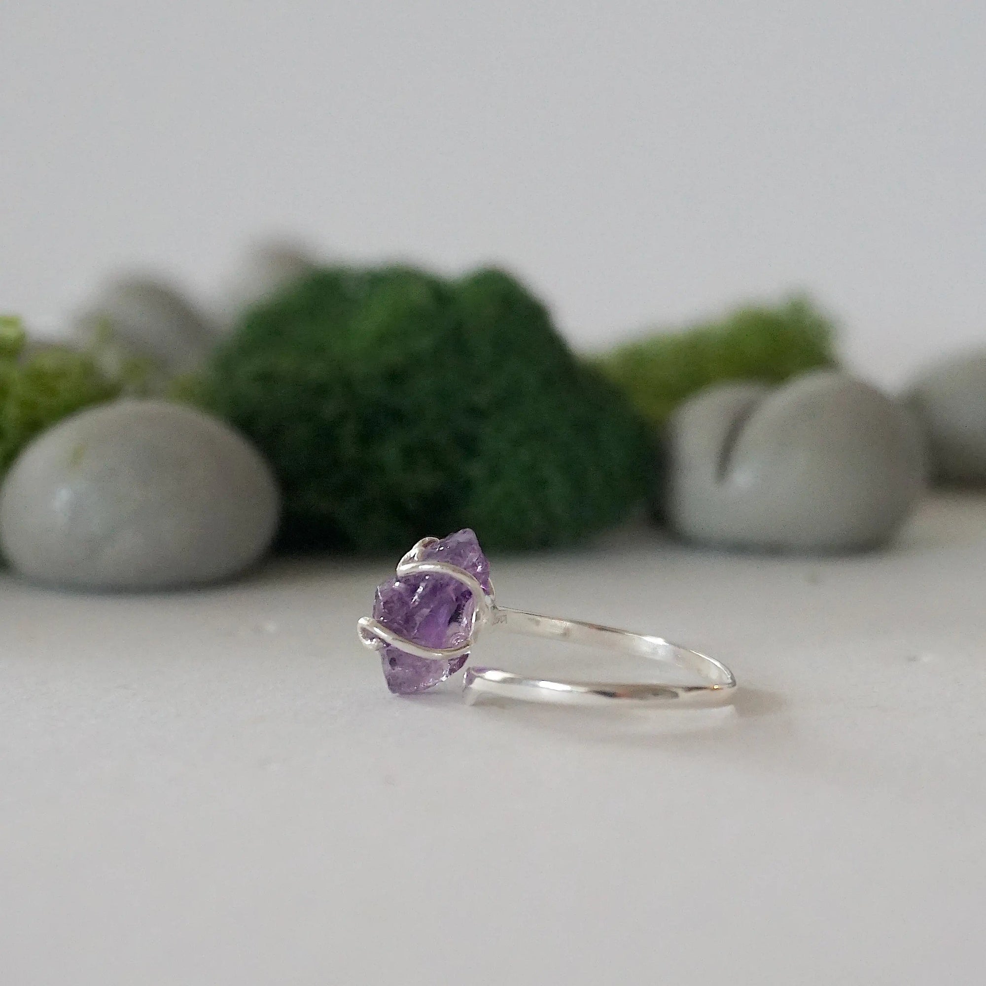 Left side detail of raw amethyst crystal ring in sterling silver claw setting, adjustable women’s ring