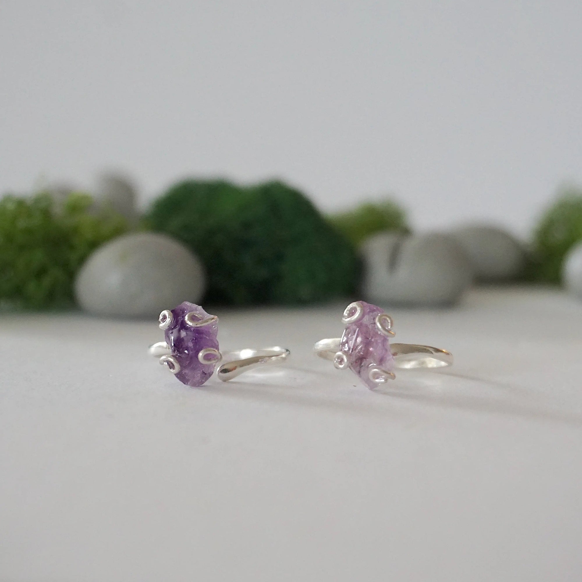 Two raw amethyst rings in sterling silver showing natural variation in crystal color, shape, and size