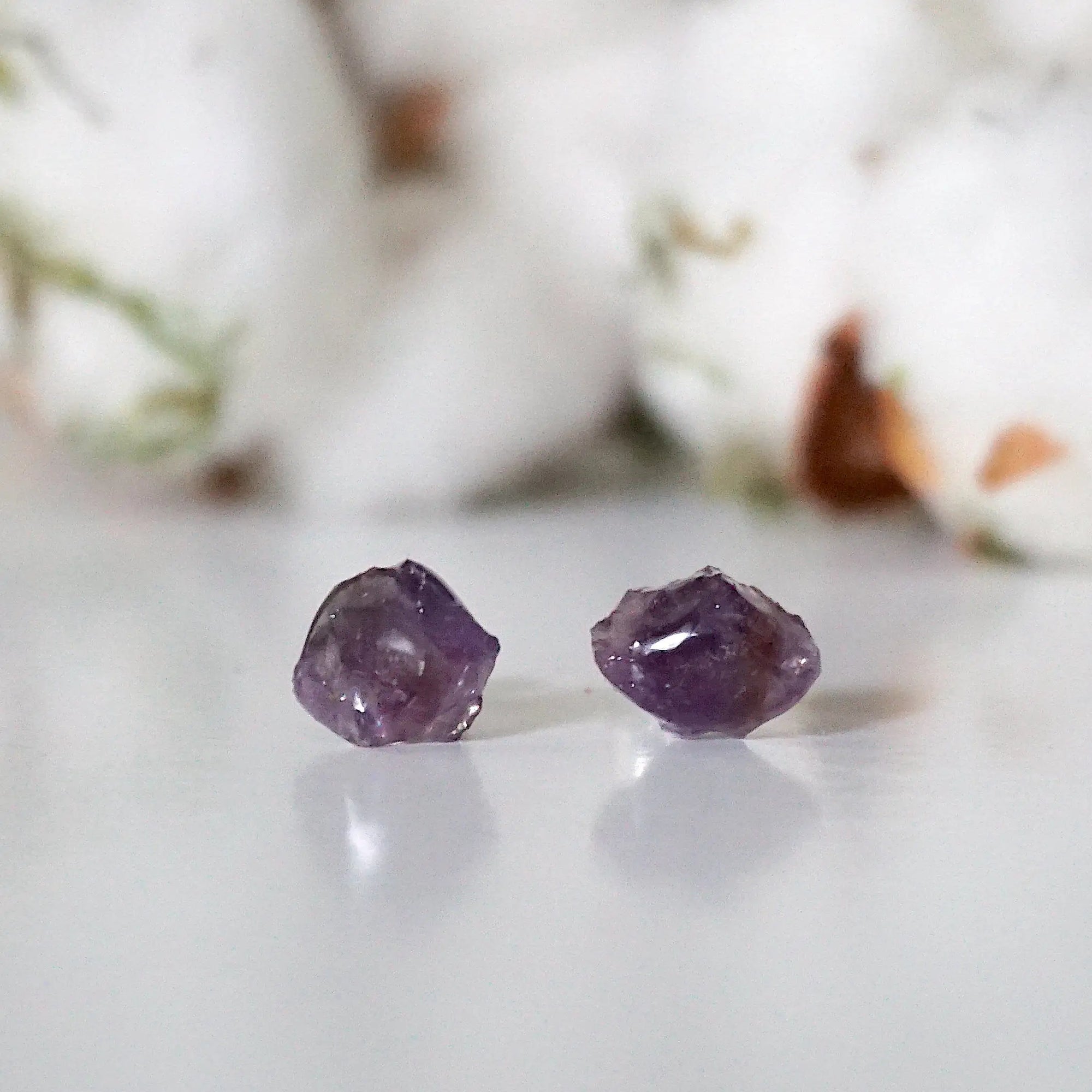 Detailed front view of raw amethyst stud earrings, unpolished natural amethyst stones on sterling silver posts