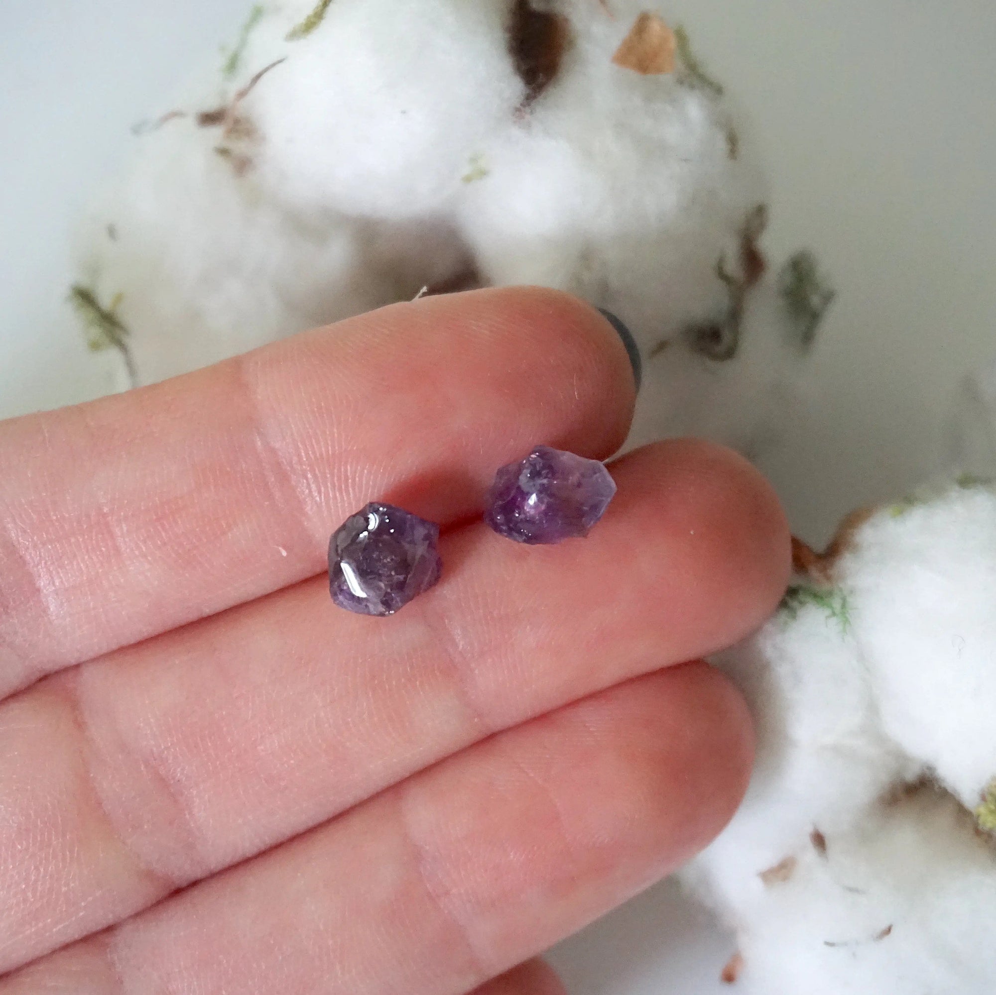 Raw amethyst stud earrings in hand for size reference, natural unpolished amethyst, sterling silver posts
