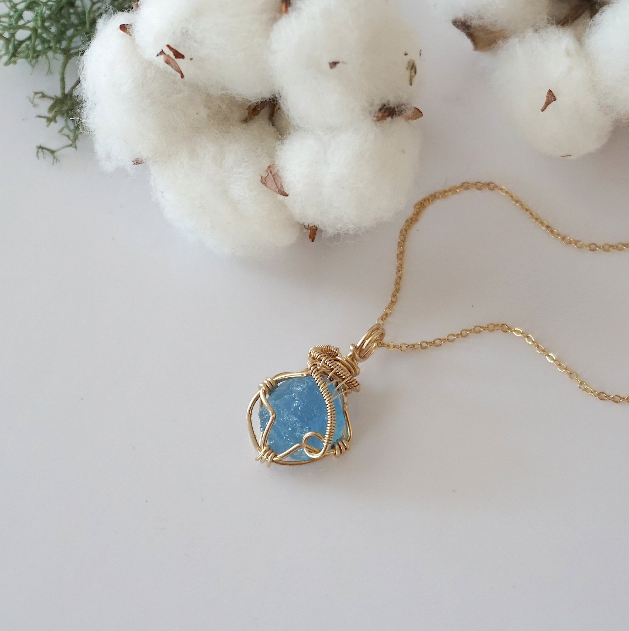 Raw aquamarine necklace in 14k gold filled laying flat. Handcrafted March birthstone jewelry for women by Designs by Nature Gems.