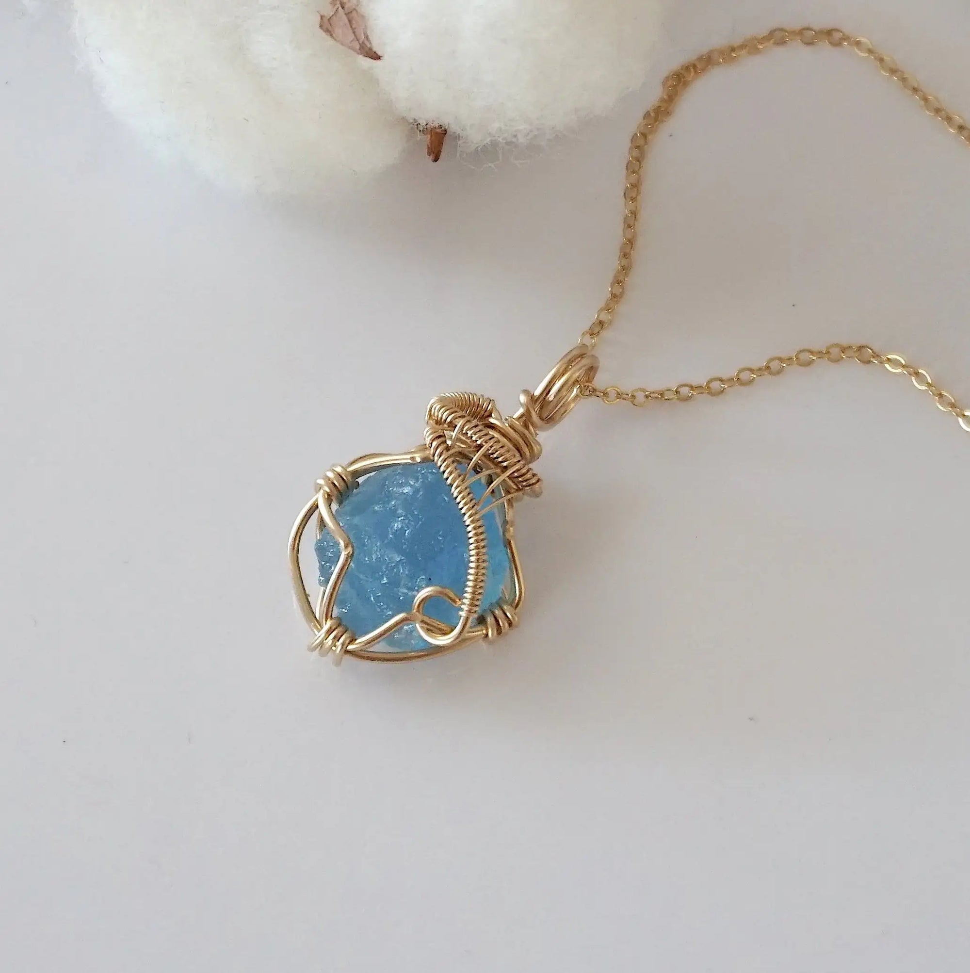 Raw aquamarine necklace in 14k gold filled laying flat. Handcrafted March birthstone jewelry for women by Designs by Nature Gems.