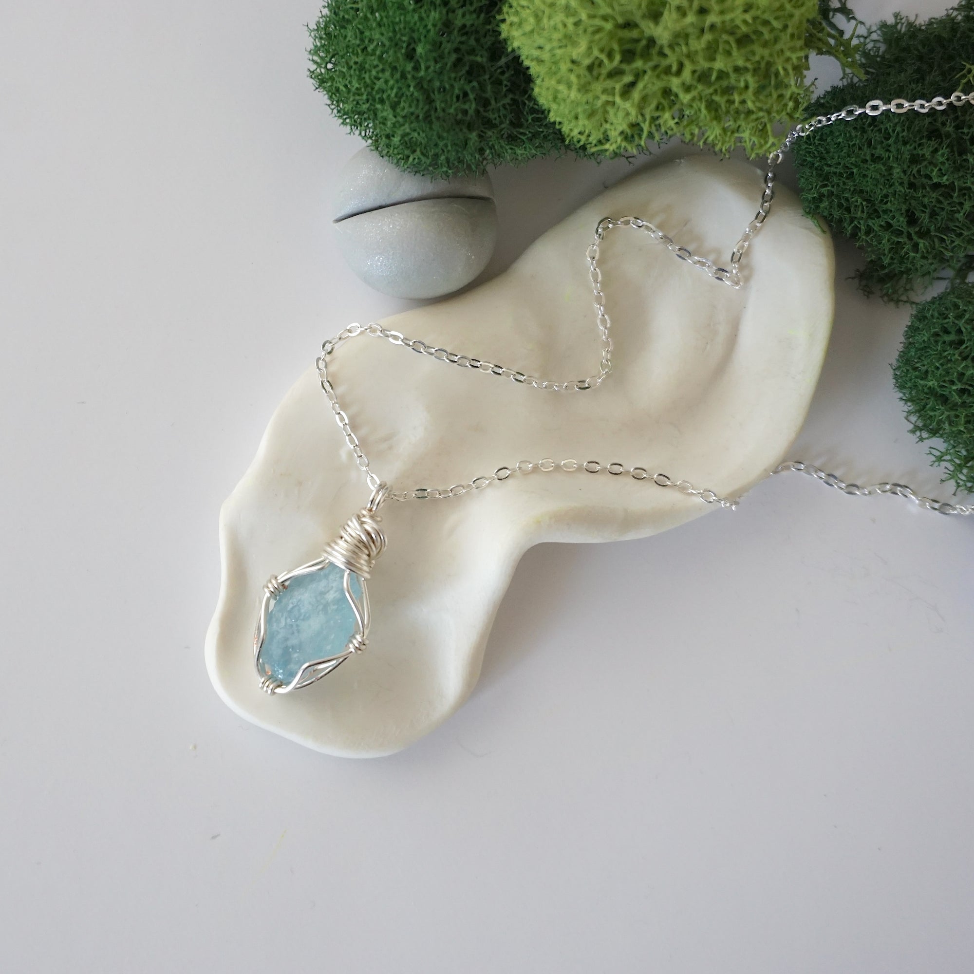 Simple raw aquamarine necklace with silver plated brass chain laying flat