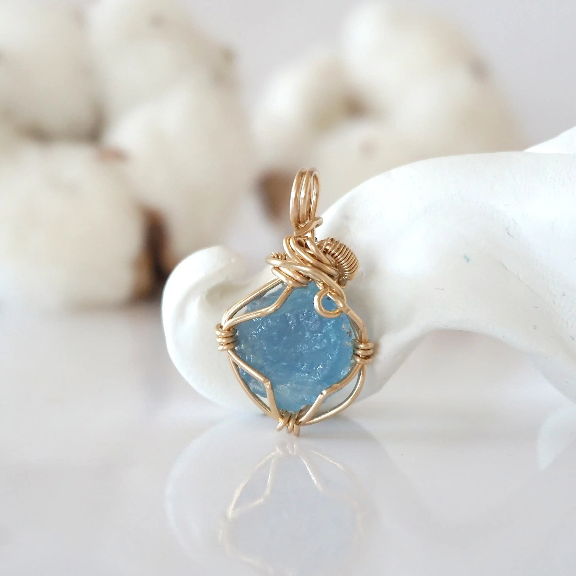 Back view of raw aquamarine pendant in 14k gold filled, highlighting stone and wire detail. One of a kind March birthstone jewelry by Designs by Nature Gems.