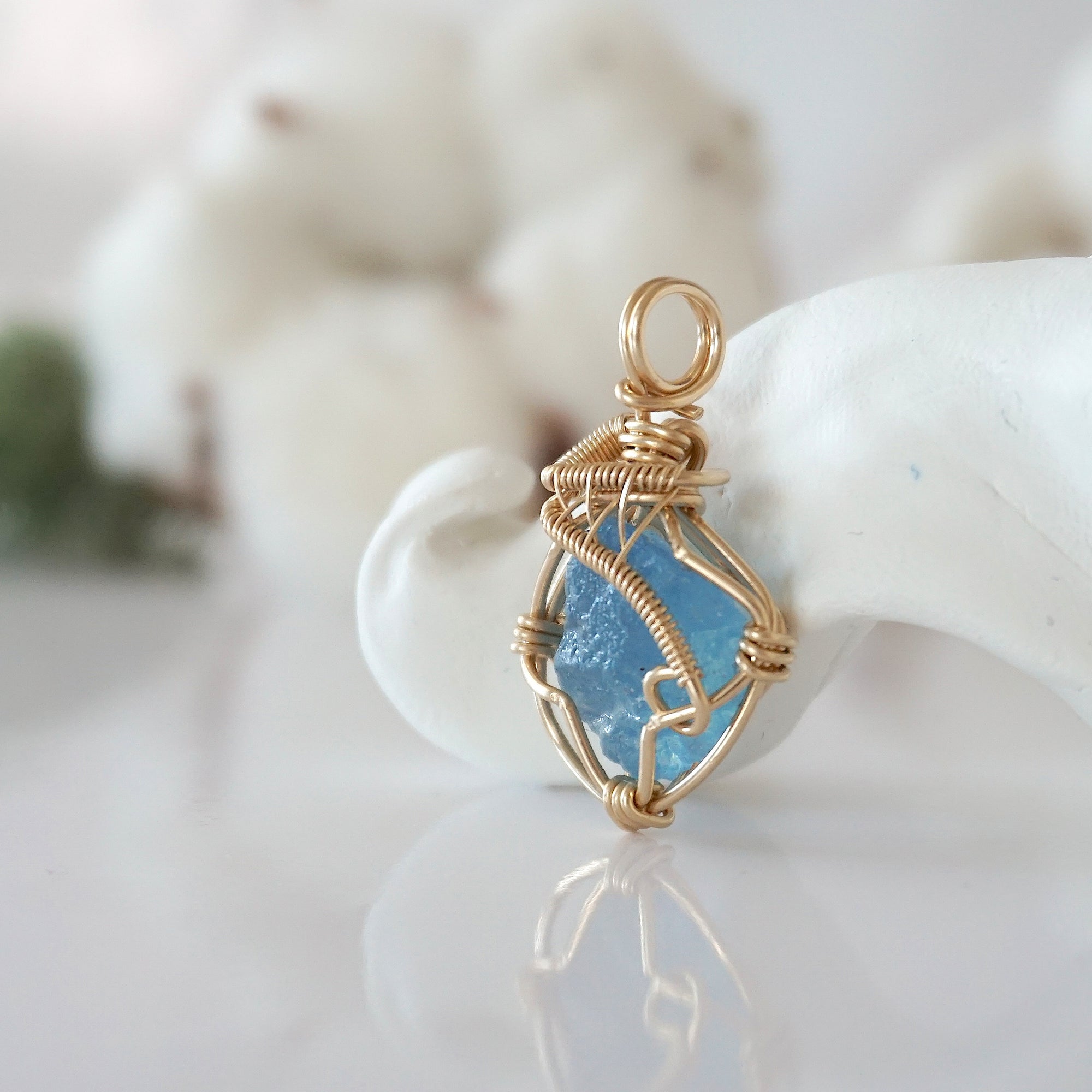 Side view of raw aquamarine pendant in 14k gold filled, showing artisan wire wrapping. Handcrafted March birthstone necklace by Designs by Nature Gems.
