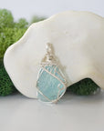 Front view of raw aquamarine pendant — natural unpolished pale blue aquamarine stone hand-wrapped in detailed 925 sterling silver wire, handcrafted artisan jewelry