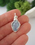 Simple raw aquamarine pendant shown in hand for size reference