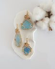 Three raw aquamarine pendants in 14k gold filled, showing natural variation in size, shape, and color. Handcrafted March birthstone jewelry by Designs by Nature Gems.