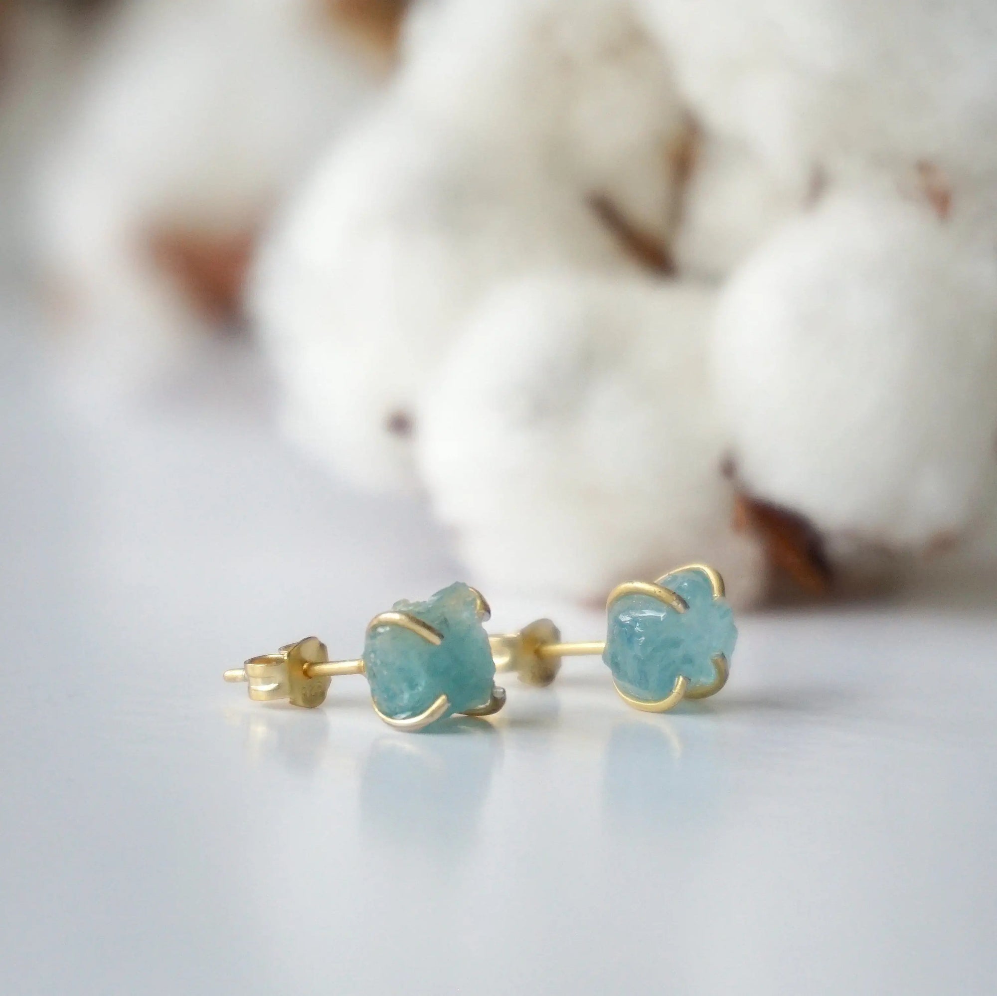 Right side angle of raw aquamarine stud earrings, minimalist gold vermeil claw setting, March birthstone