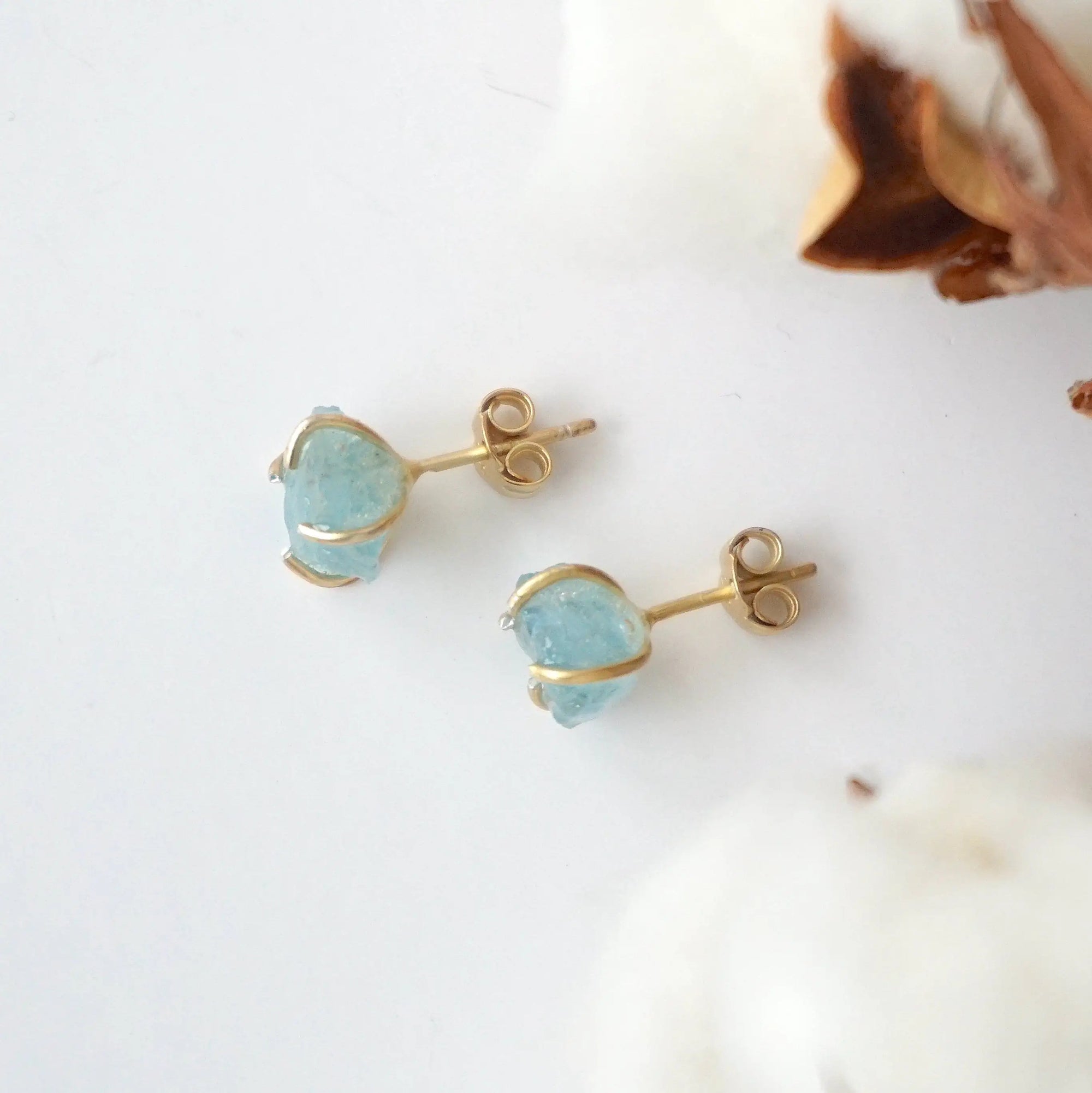 Top view of raw aquamarine stud earrings, showing prong setting and earring closure, gold vermeil
