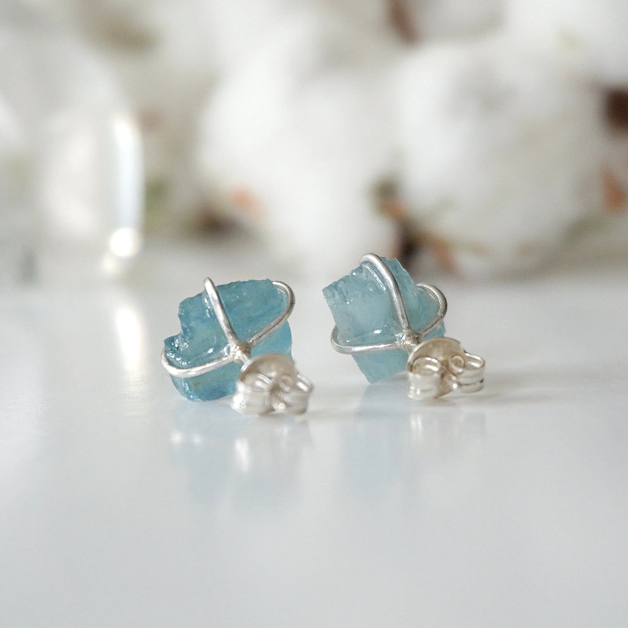 Back view of raw aquamarine stud earrings, showing prong setting and earring closure, sterling silver