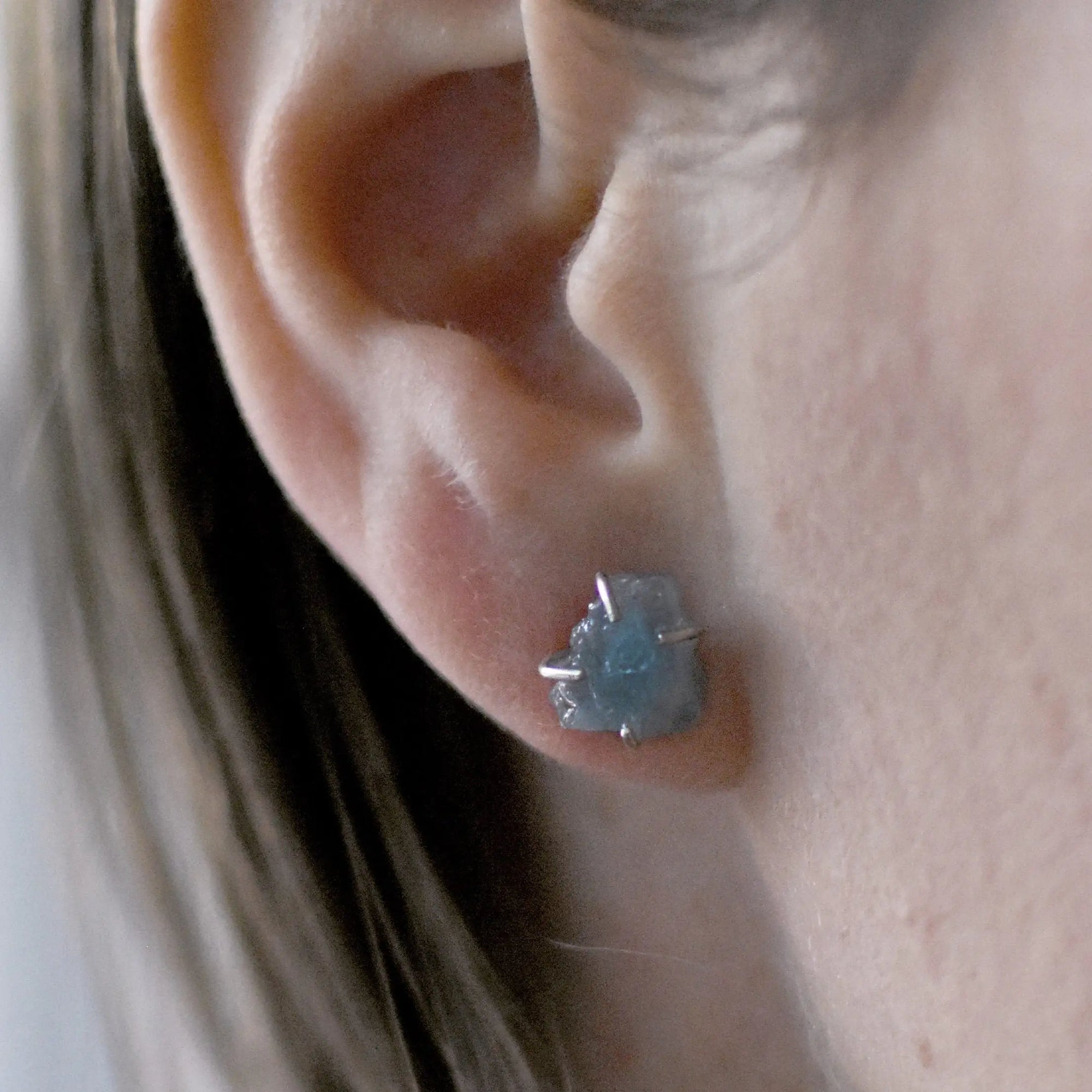 Raw aquamarine earrings in sterling silver on a female model. Handcrafted March birthstone jewelry for women by Designs by Nature Gems