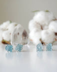 Two pairs of raw aquamarine stud earrings showing natural variation in size, shape, and blue color, Designs by Nature Gems