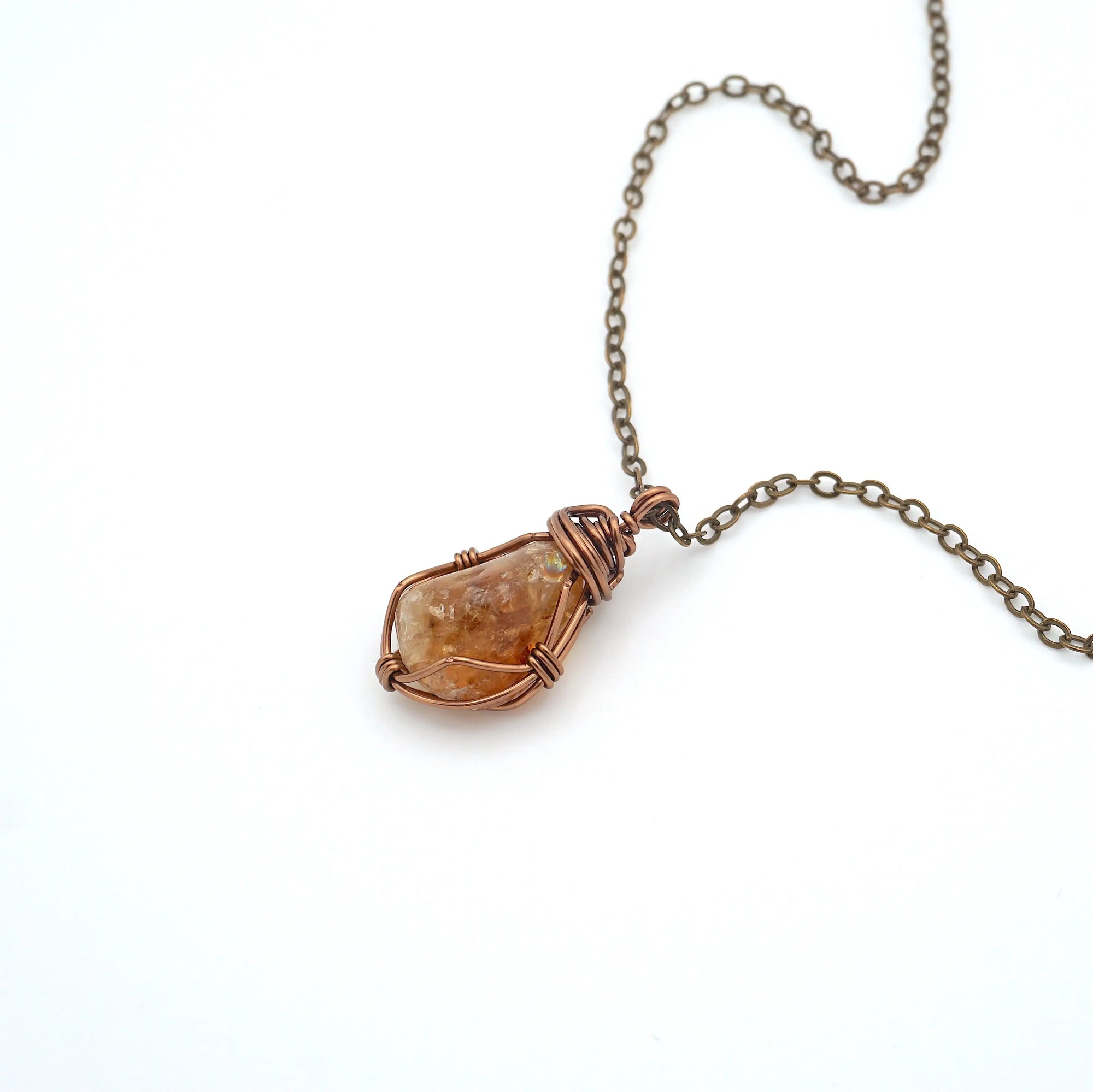 Close up of wire wrapped raw citrine crystal showing antique bronze copper craftsmanship and natural stone texture