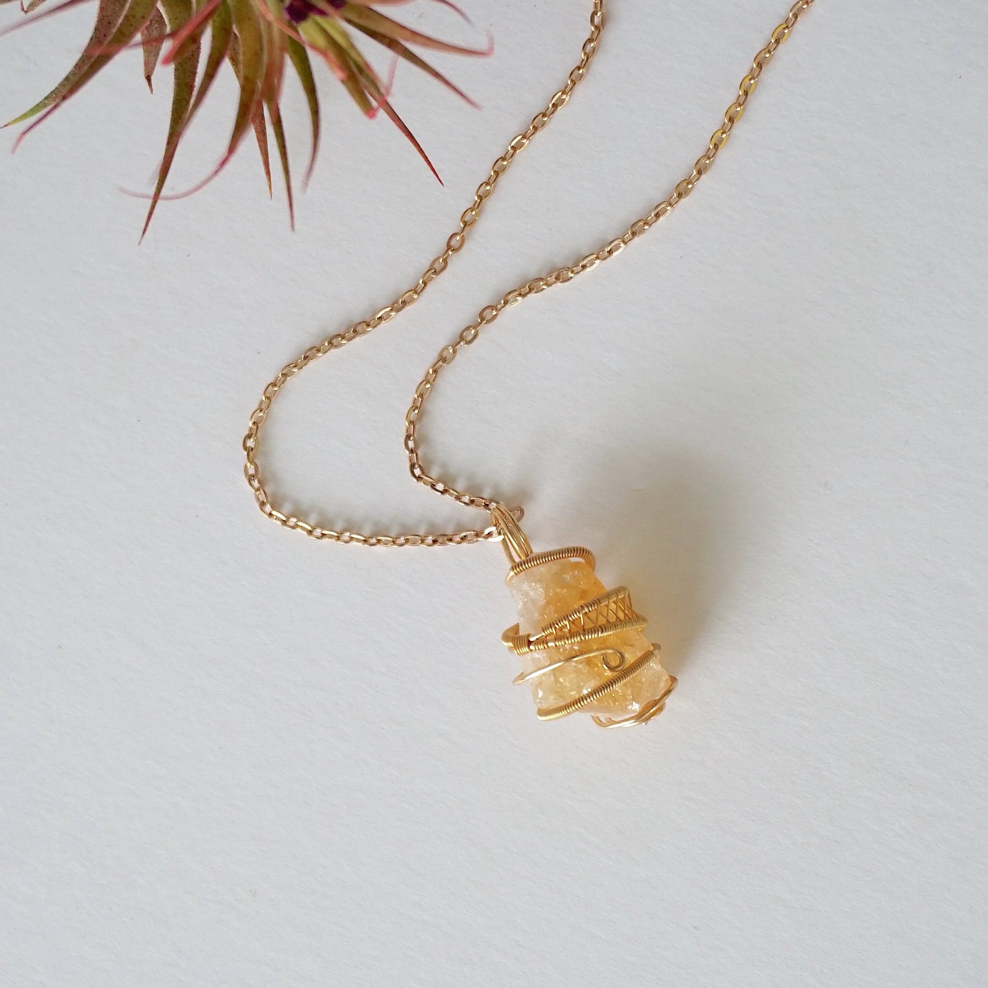 Raw citrine necklace laying flat in gold plated copper - handmade wire wrapped natural unpolished crystal pendant with chain full view November birthstone jewelry