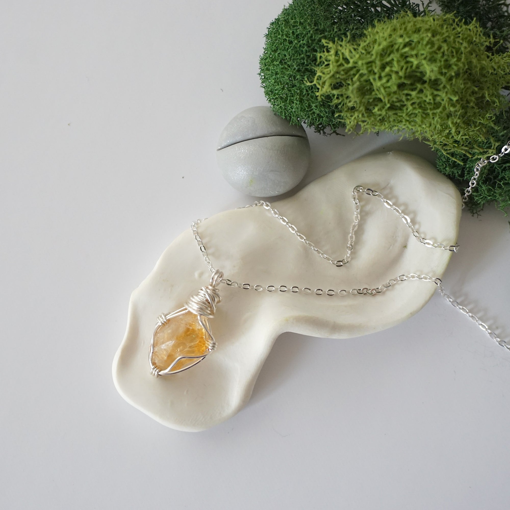 Simple raw citrine necklace with silver plated brass chain laying flat