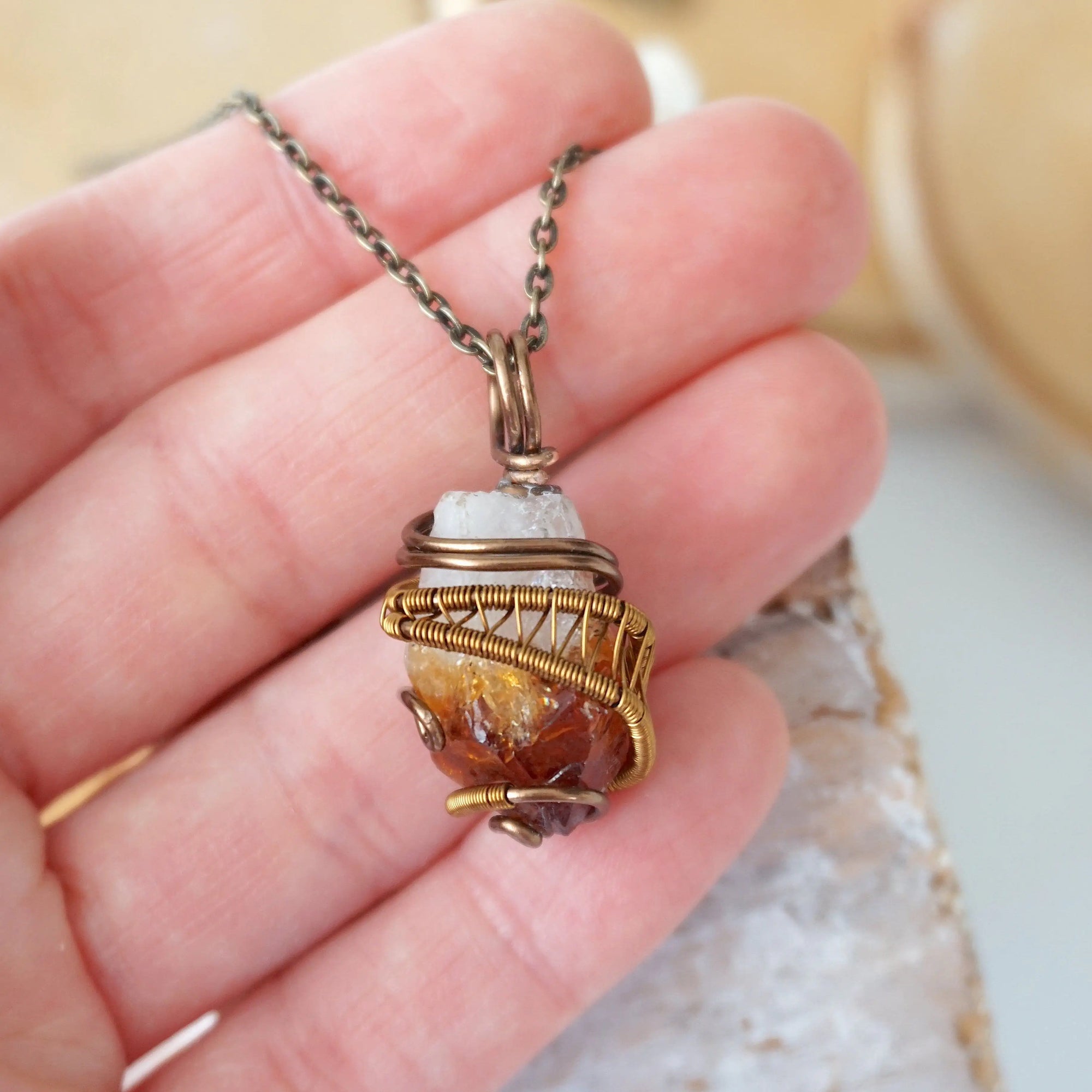 Raw citrine pendant held in hand showing size wire wrapped in antique bronze copper unisex necklace
