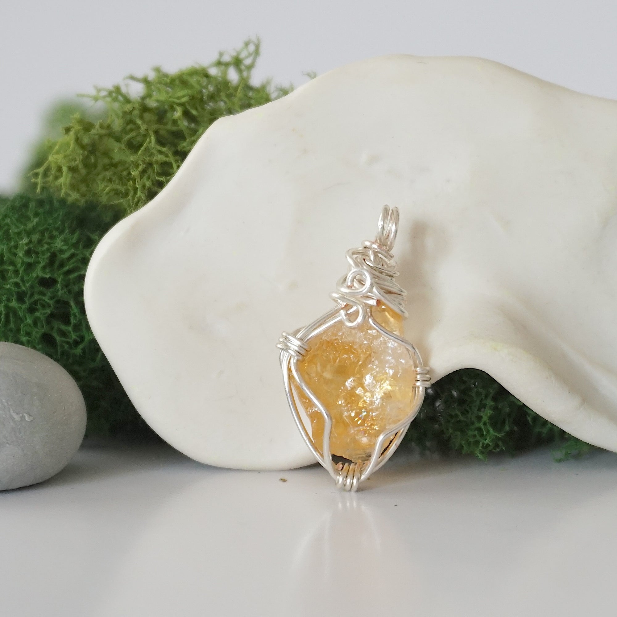 Back angle look at simple raw citrine pendant with silver wire wrapping
