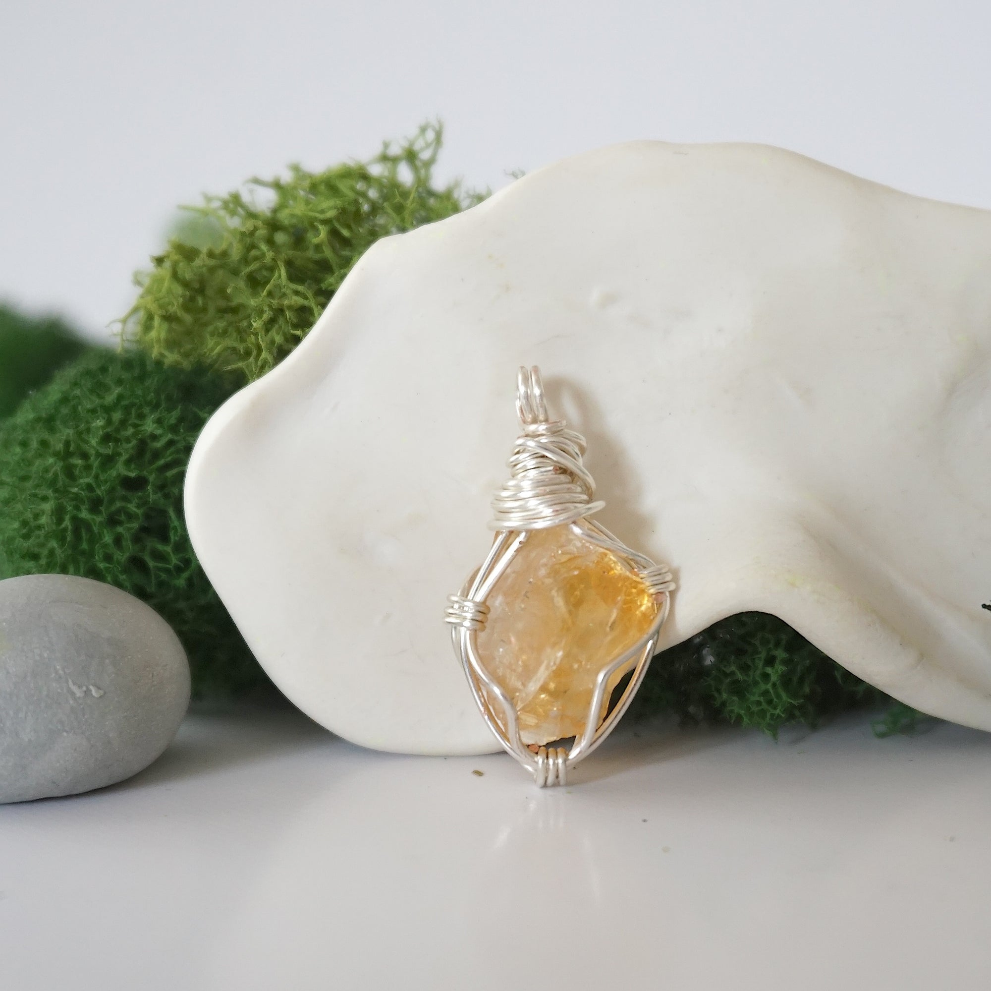 Detailed front angle view of simple raw citrine pendant in silver wire