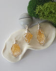 Three different raw citrine pendants displayed for variation reference