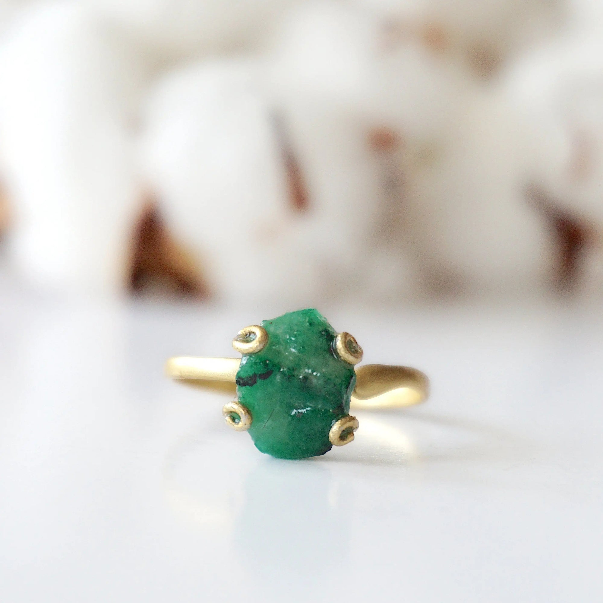 Front detail of raw emerald adjustable ring in gold vermeil showing natural emerald stone and artisan setting