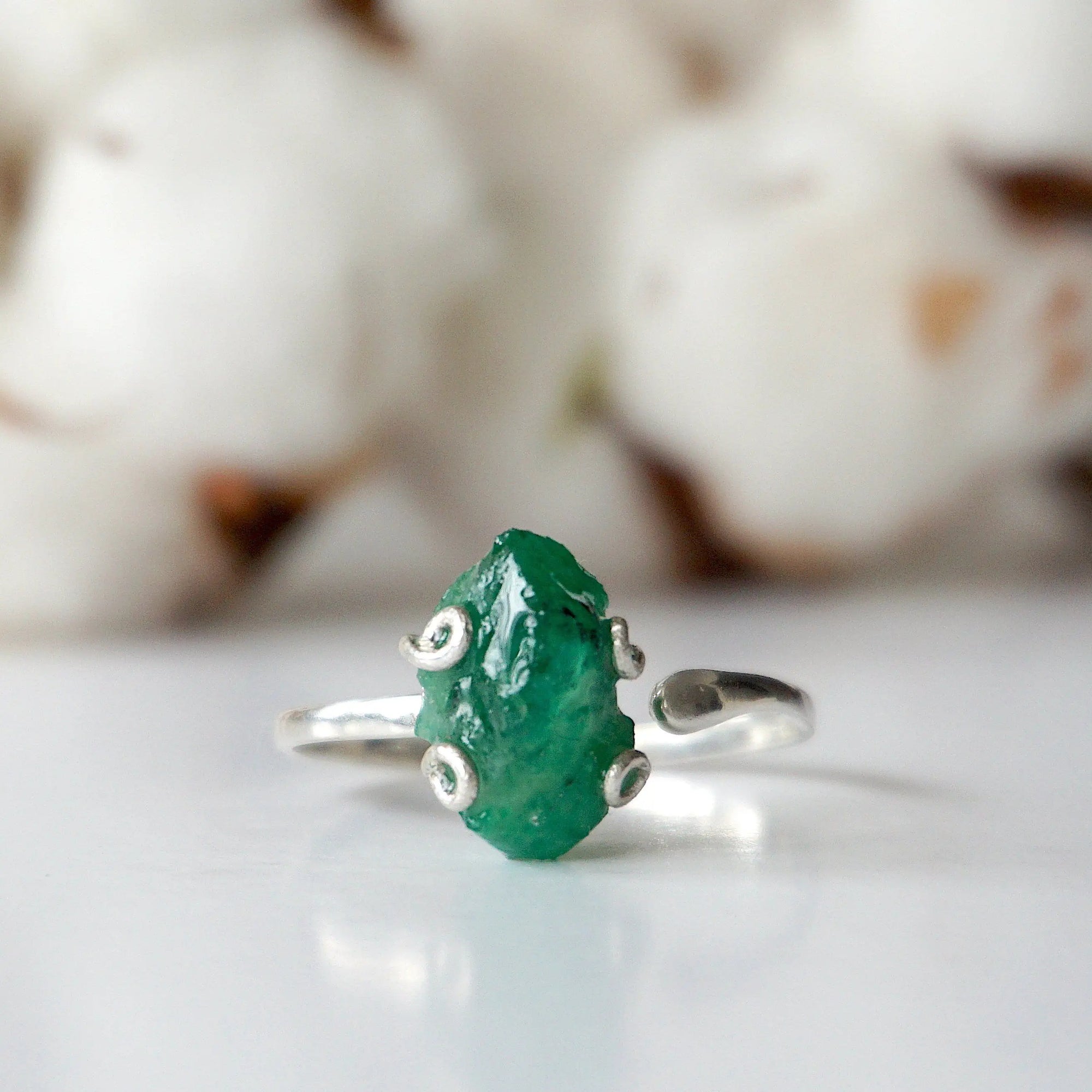 Front detail of raw emerald adjustable ring in sterling silver showing natural emerald stone and artisan setting