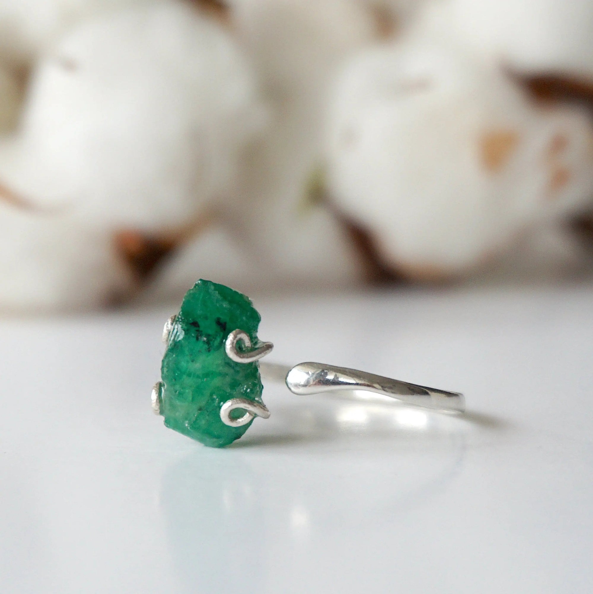 Left side view of raw emerald ring in sterling silver with adjustable band and handcrafted artisan details