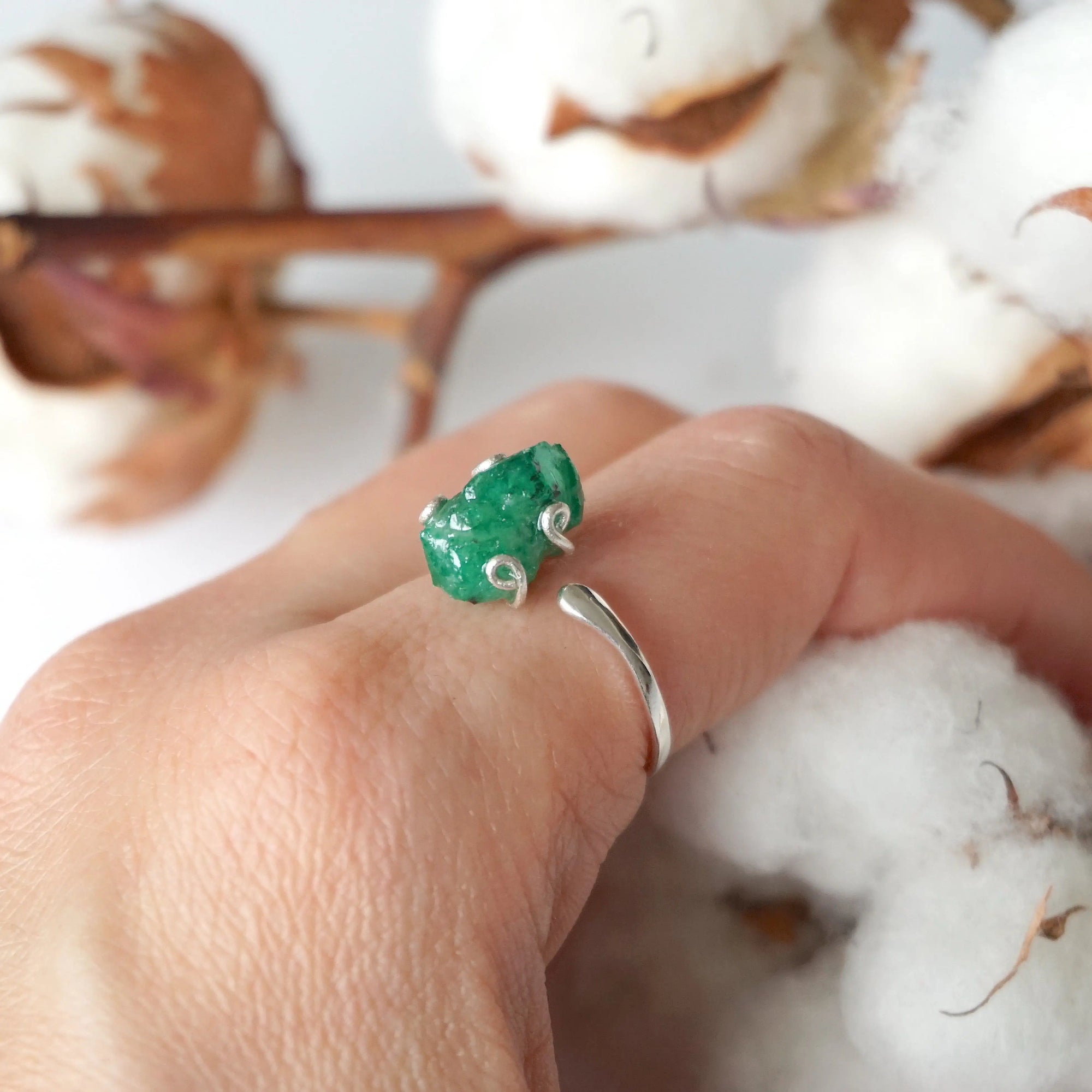 Raw emerald adjustable ring in sterling silver worn on a woman's hand, natural May birthstone ring for women