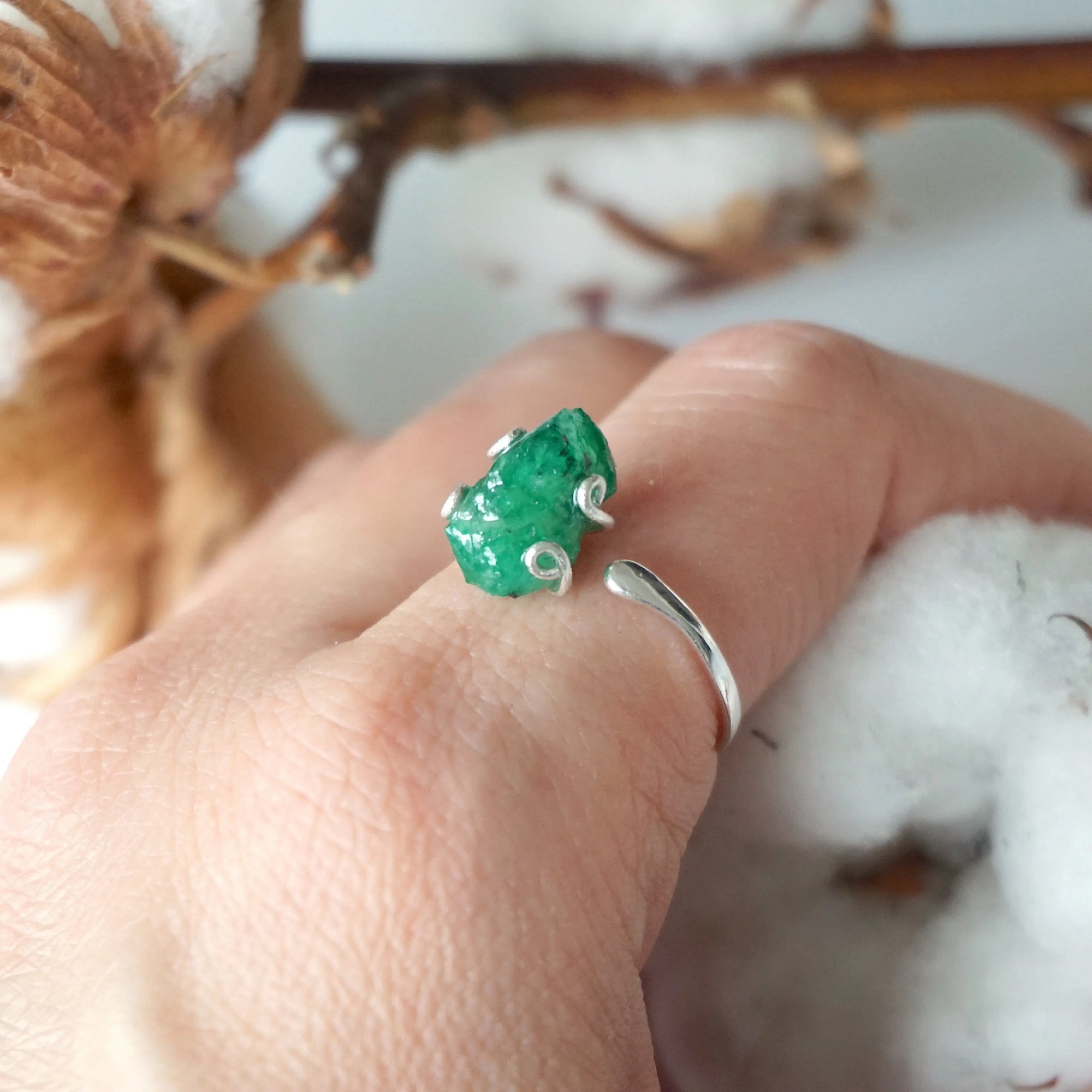 Natural raw emerald ring in sterling silver on female hand, adjustable artisan gemstone ring for women