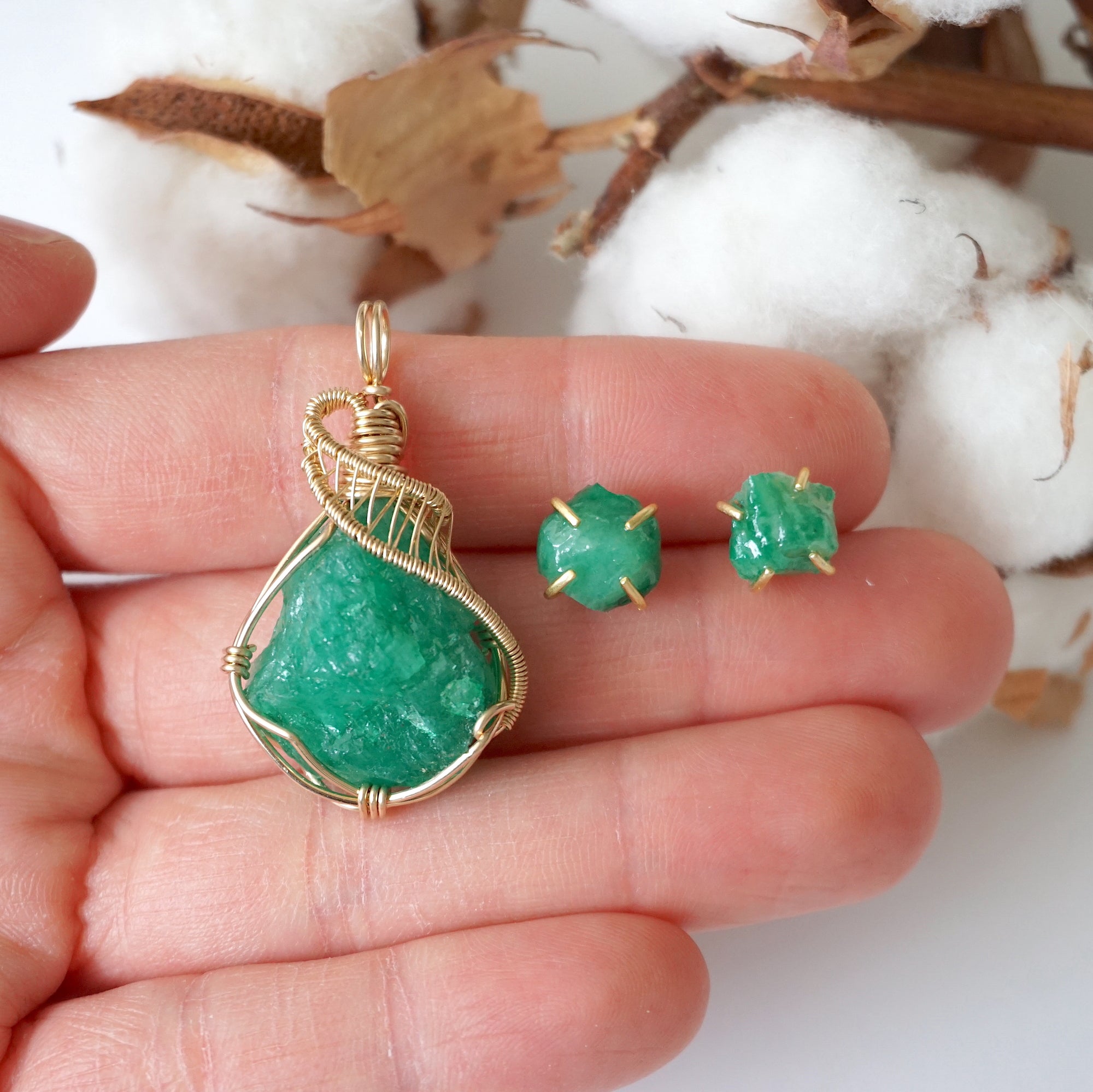 Raw emerald necklace and stud earrings set in 14k gold filled shown in hand for size reference. Artisan May birthstone jewelry set by Designs by Nature Gems.