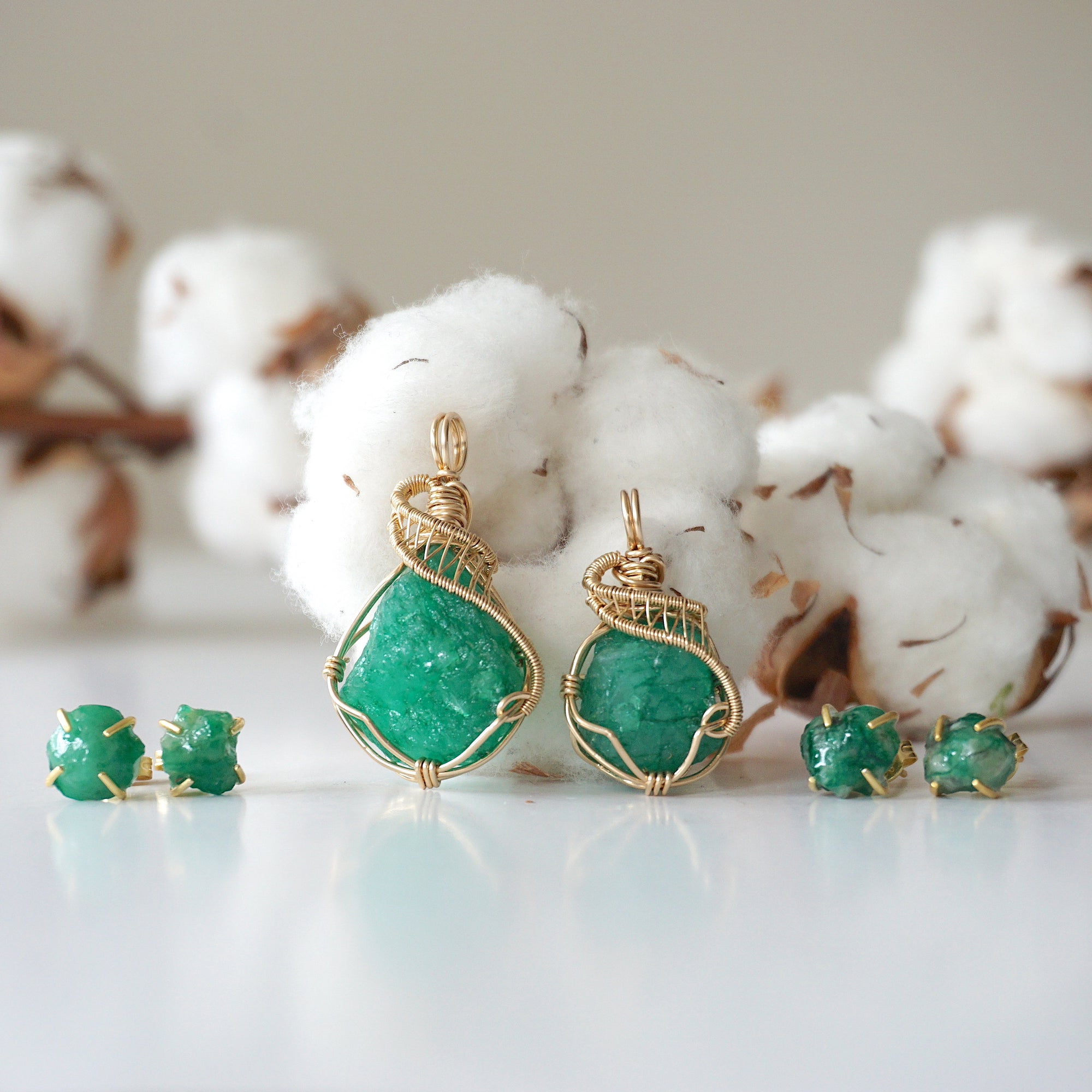 Two raw emerald jewelry sets in 14k gold filled, showing natural variation in size, shape, and color. Handcrafted May birthstone jewelry set by Designs by Nature Gems.