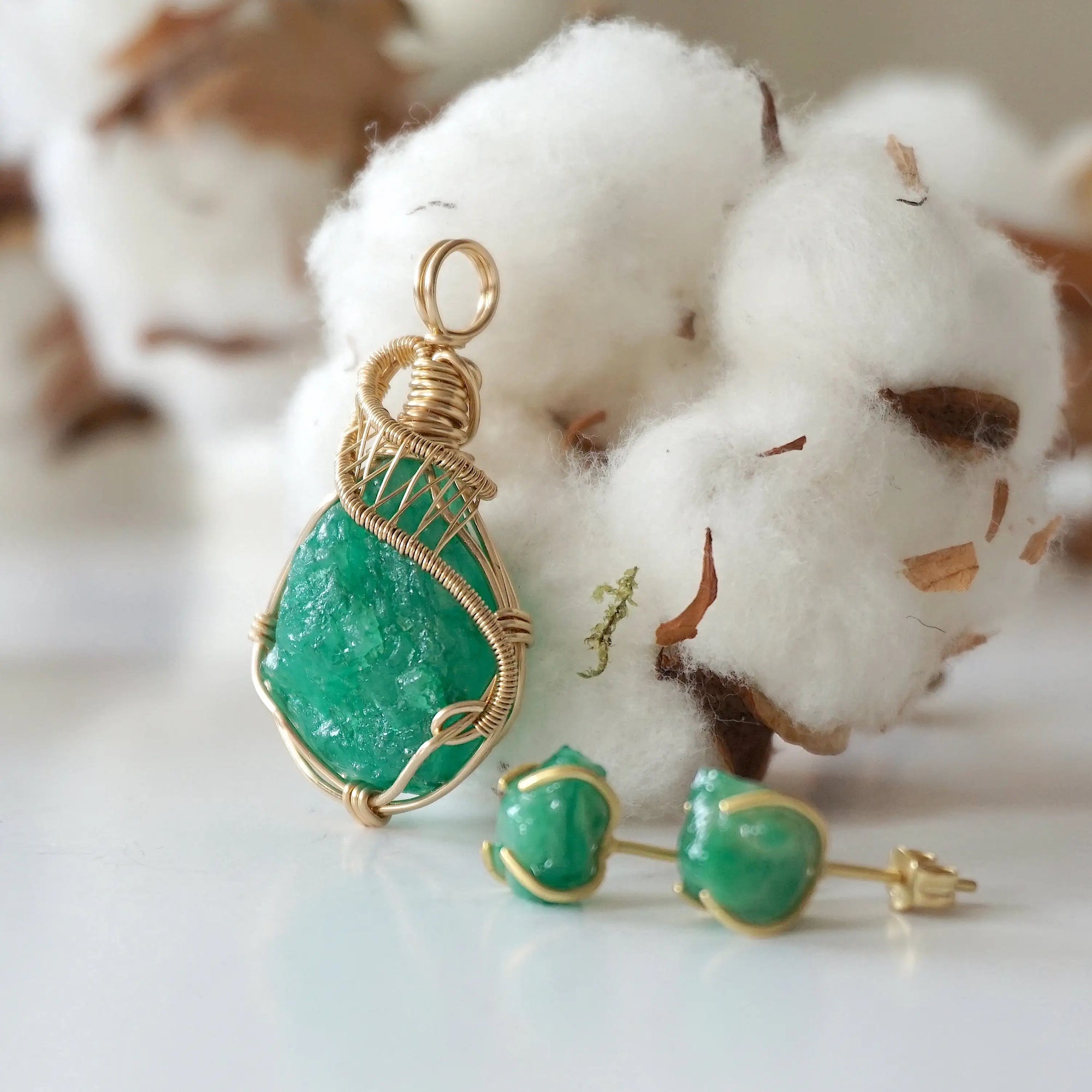 Left side view of raw emerald necklace pendant in 14k gold filled, showing artisan wire wrapping. Handcrafted May birthstone necklace by Designs by Nature Gems.